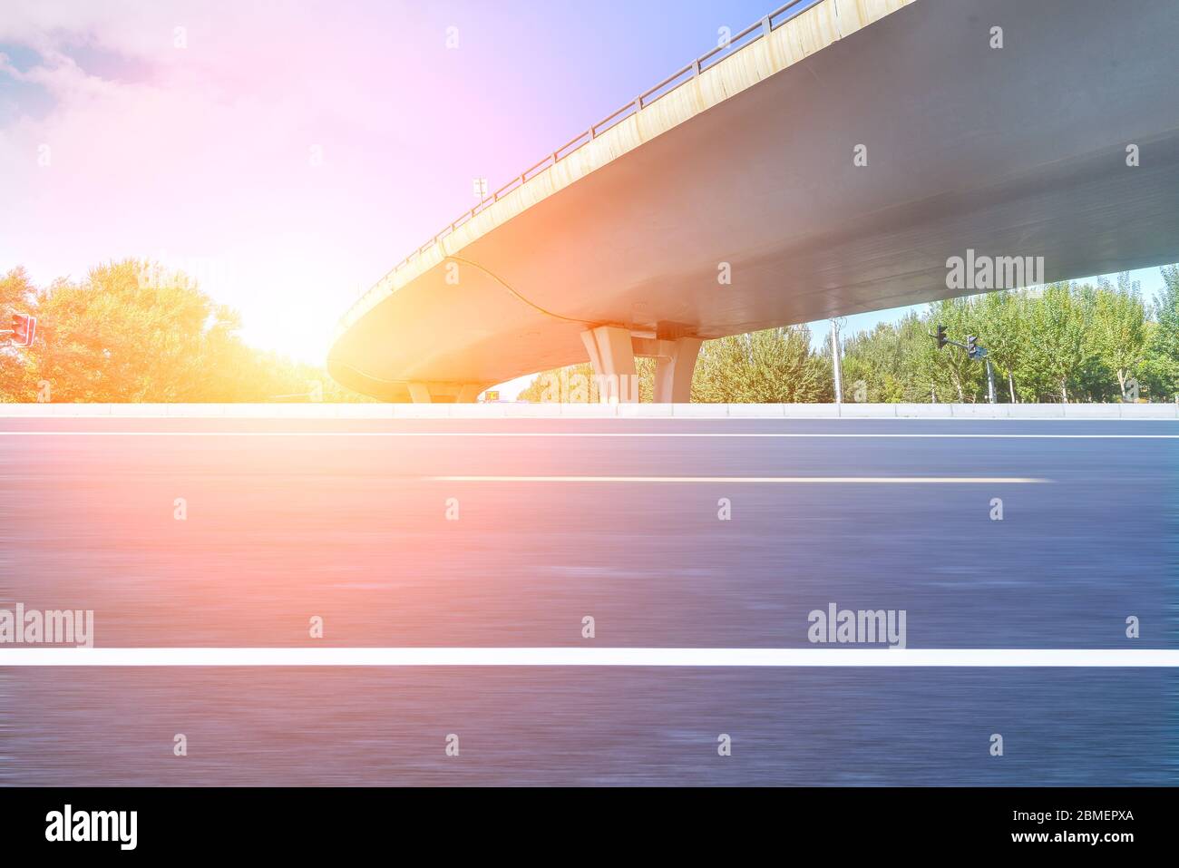 Under the overpass, car-free asphalt road, modern city building skyline as background. Stock Photo