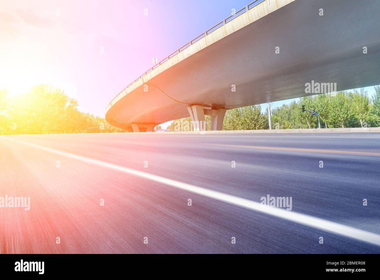 Under the overpass, car-free asphalt road, modern city building skyline as background. Stock Photo