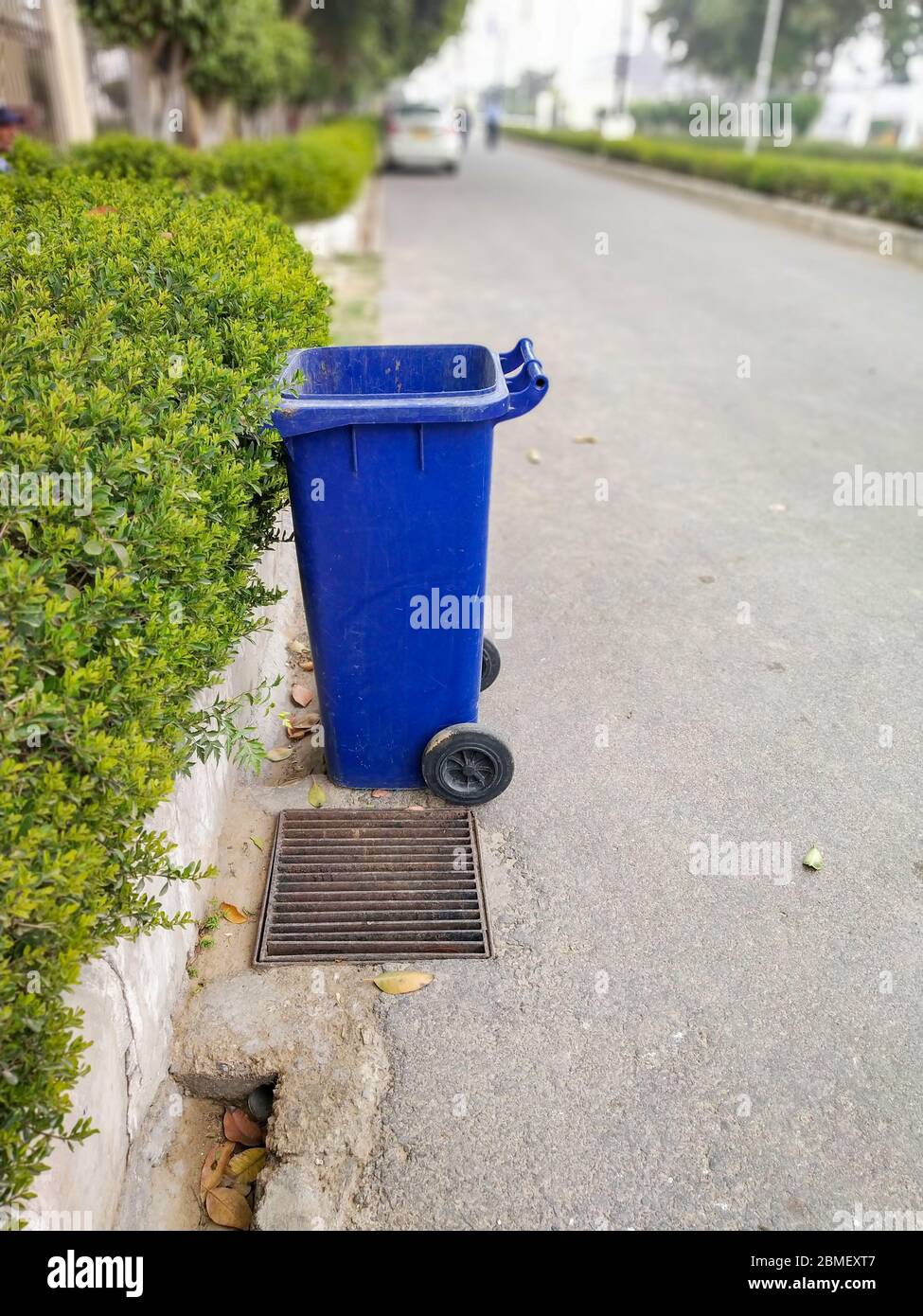 Blue colored dustbin at roadside to keep city clean Stock Photo