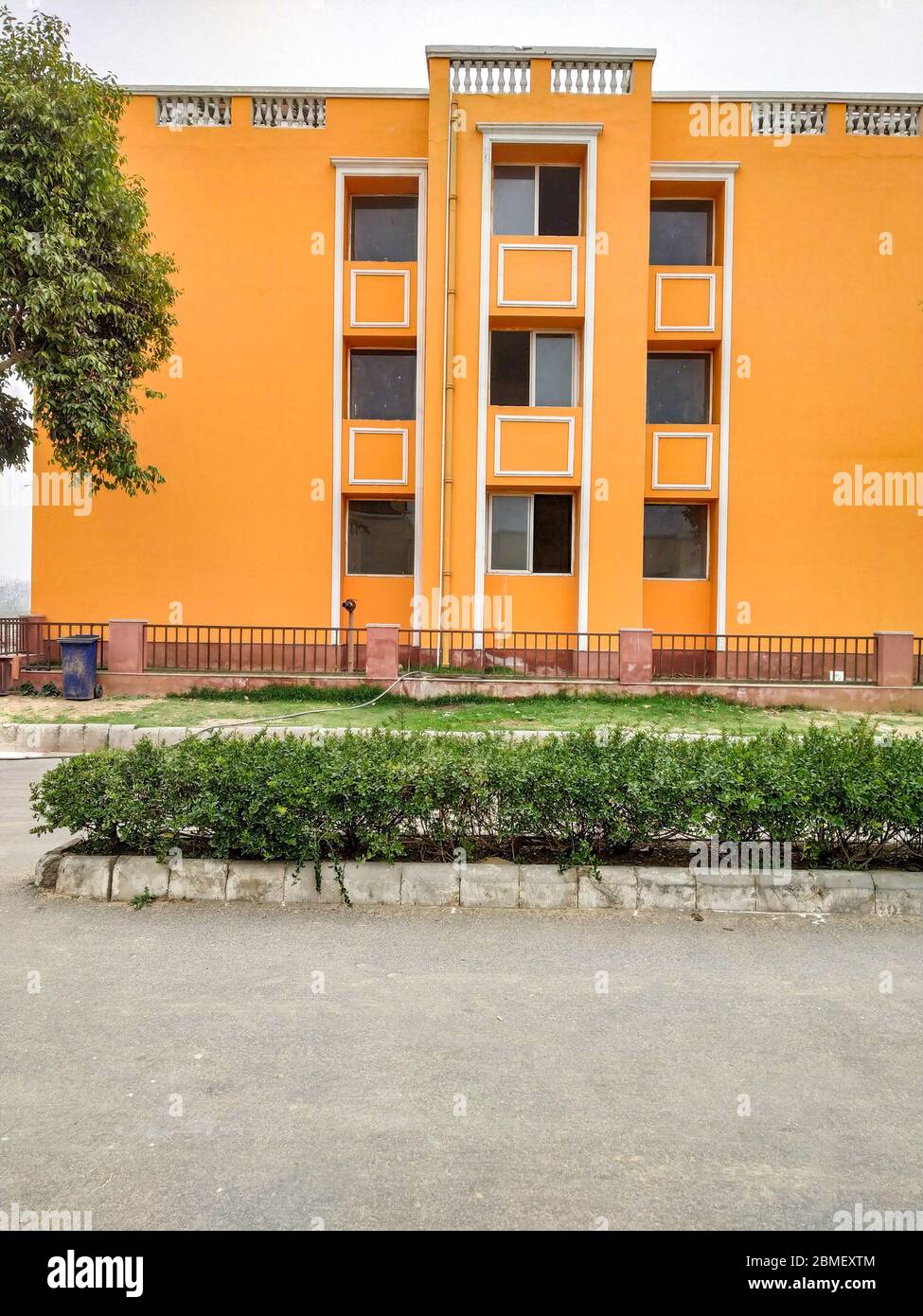 Orange colored house in the city with multiple parallel windows Stock Photo