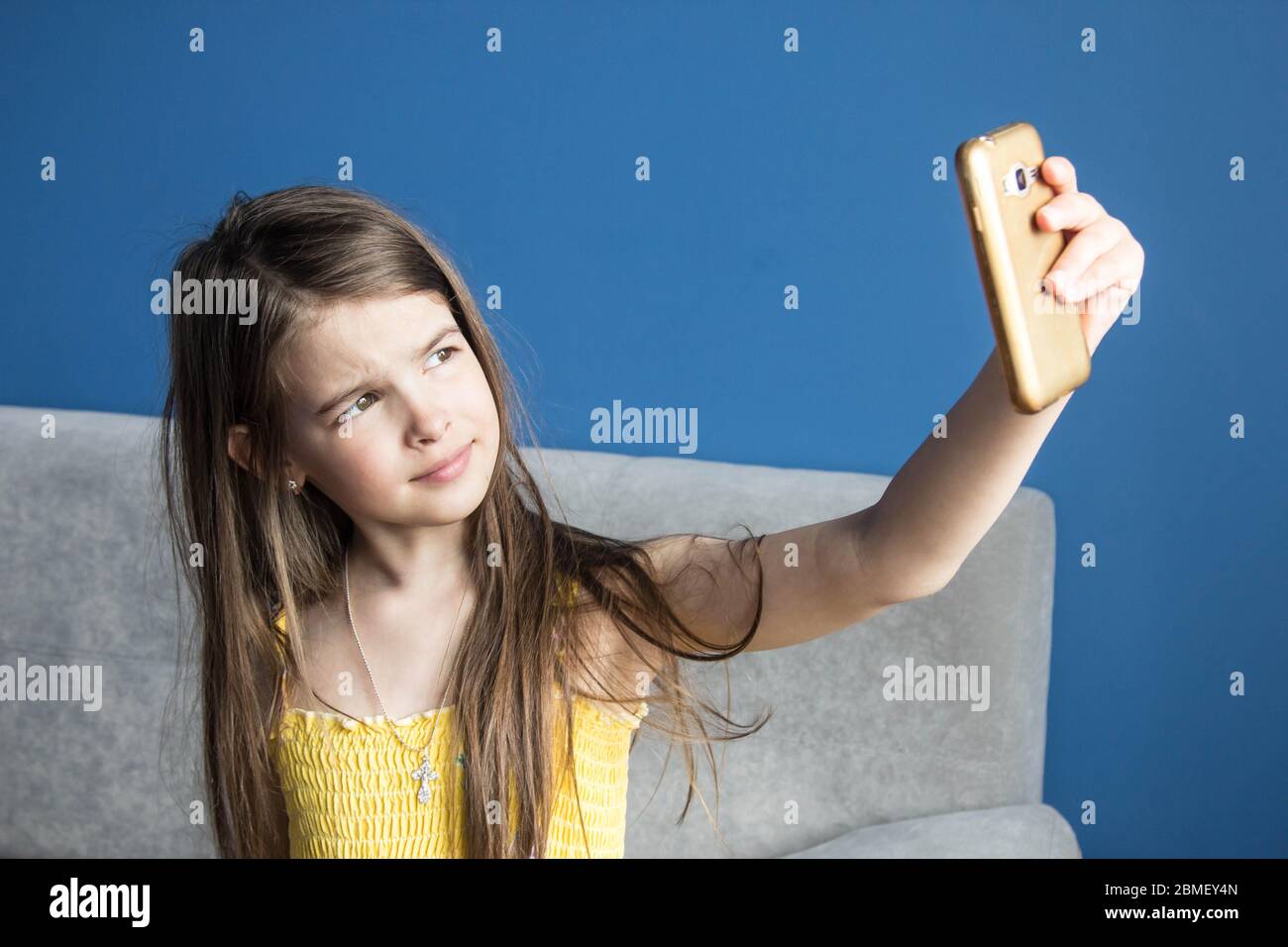 girl takes a selfie on her phone in a room with blue walls Stock Photo ...