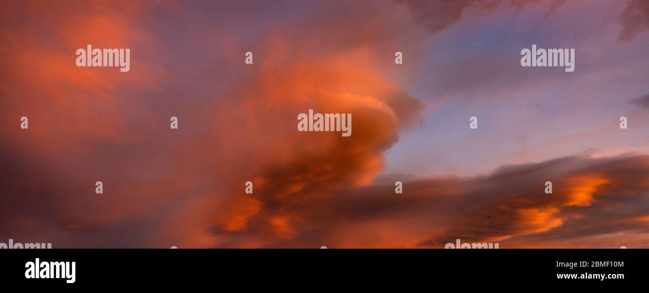 Bloody orange clouds in the evening sky as a natural background Stock Photo
