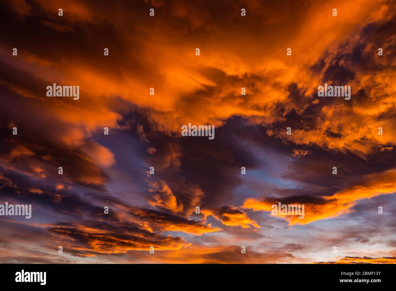 Bloody orange clouds in the evening sky as a natural background Stock Photo