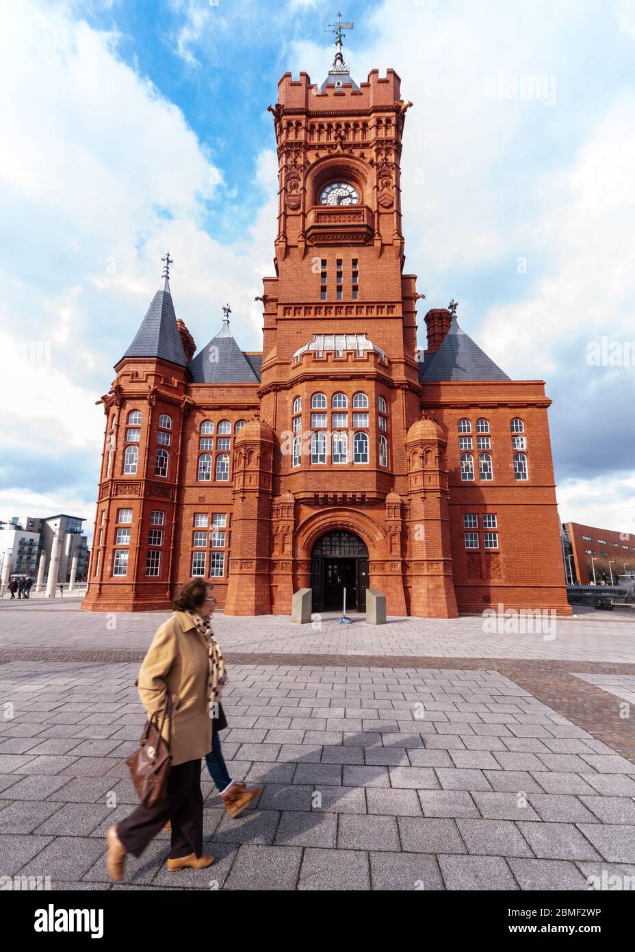 Cardiff, Wales, UK - March 17, 2013: Pedestrians walk past the ornate Victorian Pierhead building in Cardiff Bay. Stock Photo