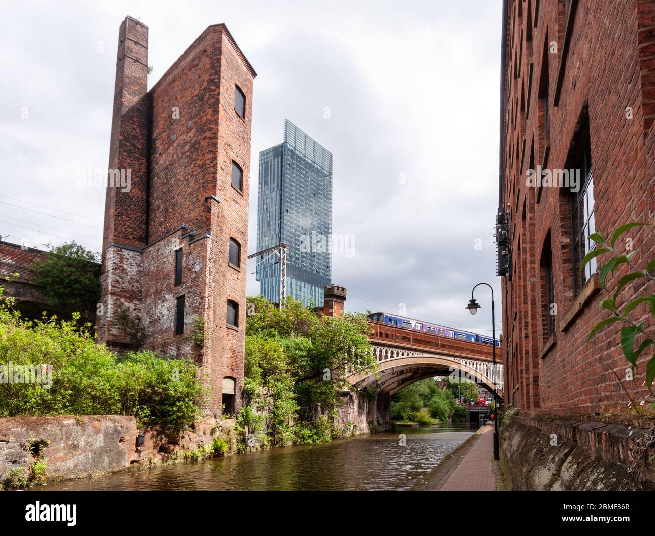 Manchester, England, UK - May 21, 2011: An industrial engine house and the modern Beetham Tower skyscraper rise above the Bridgewater Canal and railwa Stock Photo