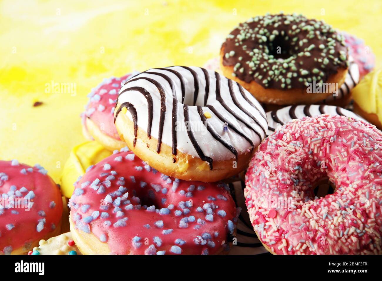 assorted donuts with chocolate frosted, pink glazed and sprinkles donuts. Stock Photo