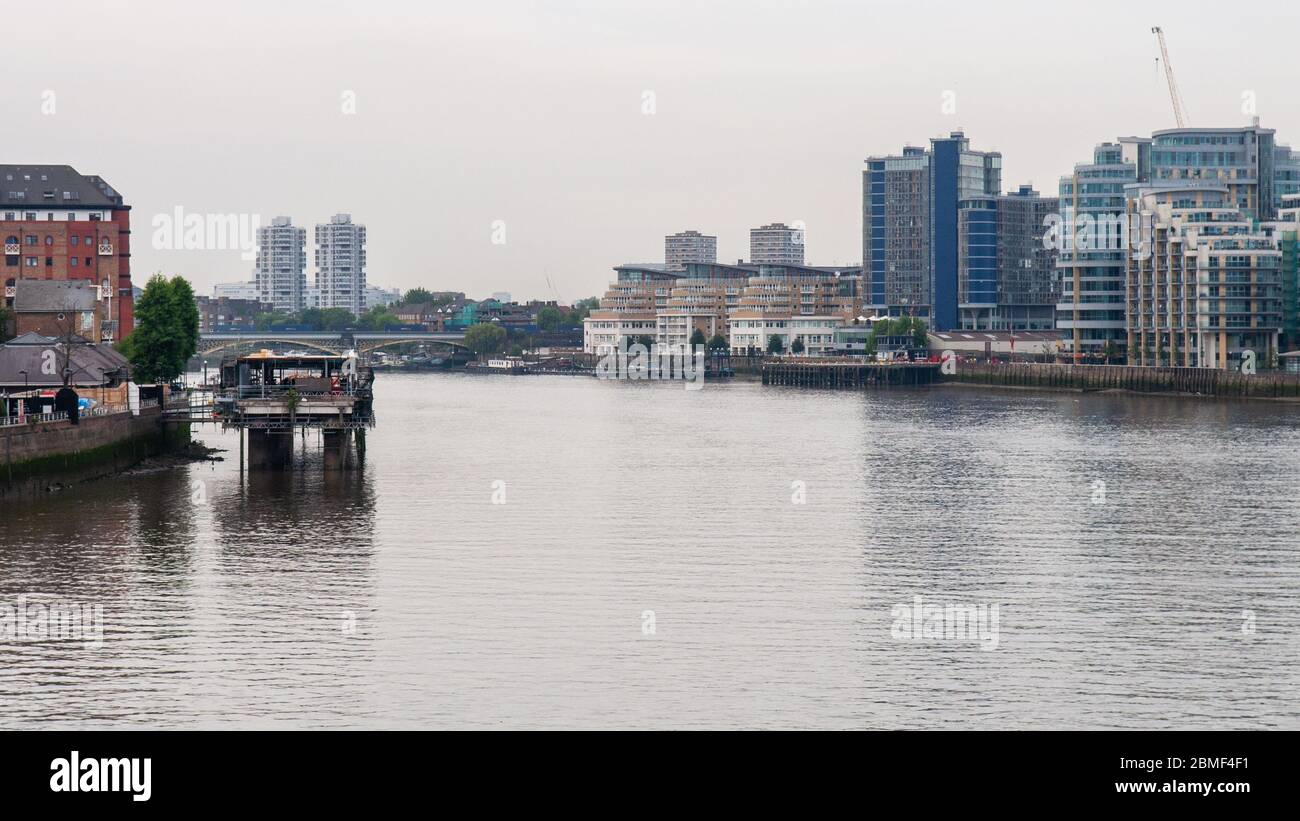 London, England, UK - June 18, 2013: A freight train crosses the River Thames on the West London Line's Battersea Railway Bridge, beside high rise tow Stock Photo