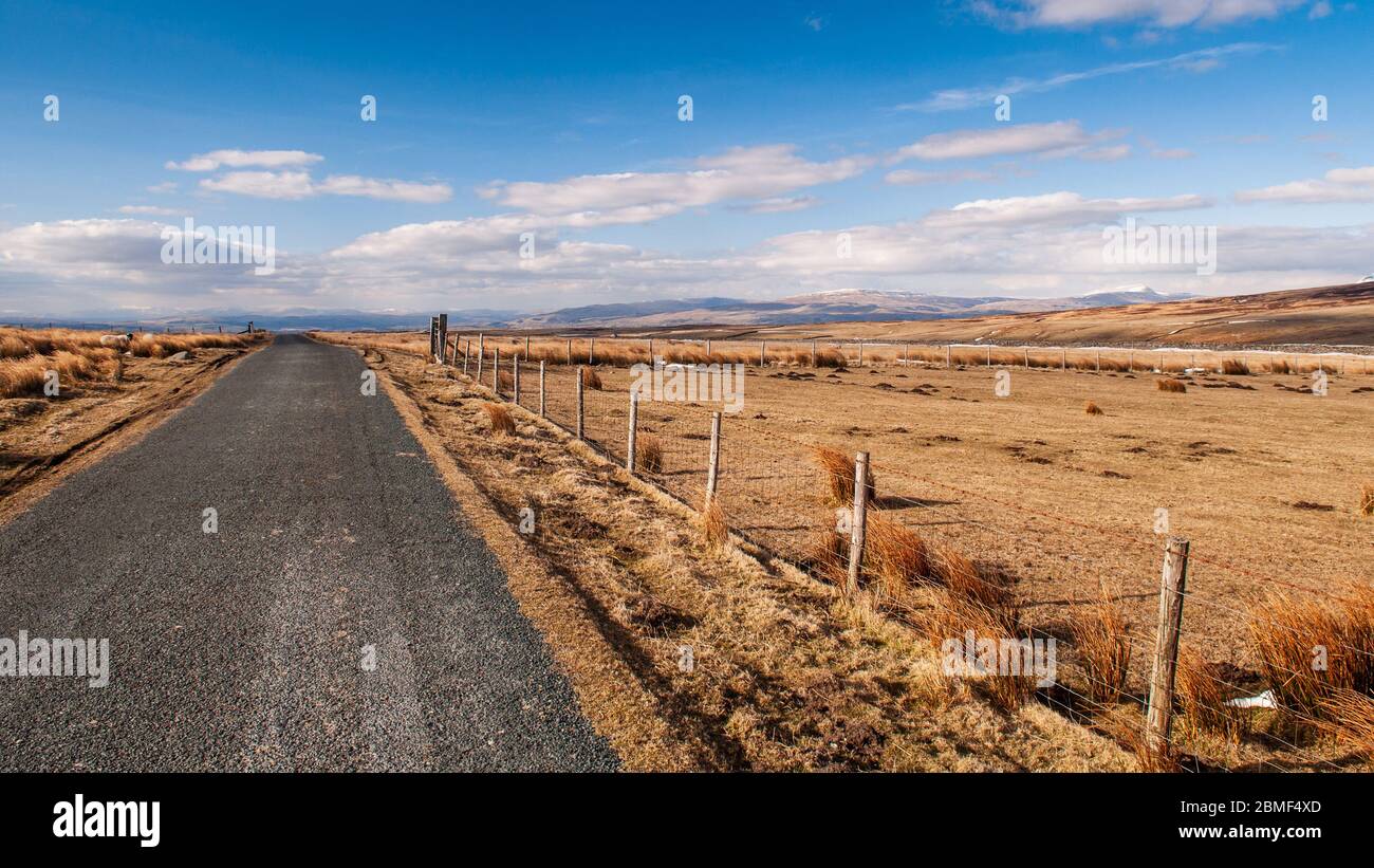 A country lane crosses the moors of the Forest of Bowland at Cross of Greet in Lancashire, with