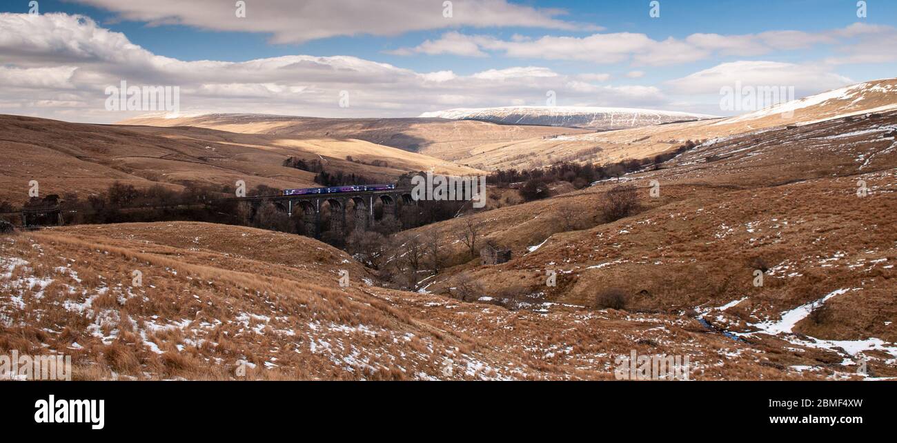 Dent, England, UK - April 1, 2013: A Northern Rail passenger train crosses Dent Head Viaduct high above Dentdale valley in the hills of the Yorkshire Stock Photo