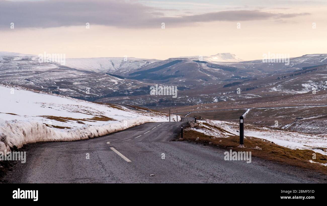 Ingleborough mountain and other snow-capped hills rise above Widdale and Wensleydale valleys under the Buttertubs Pass road in England's Yorkshire Dal Stock Photo