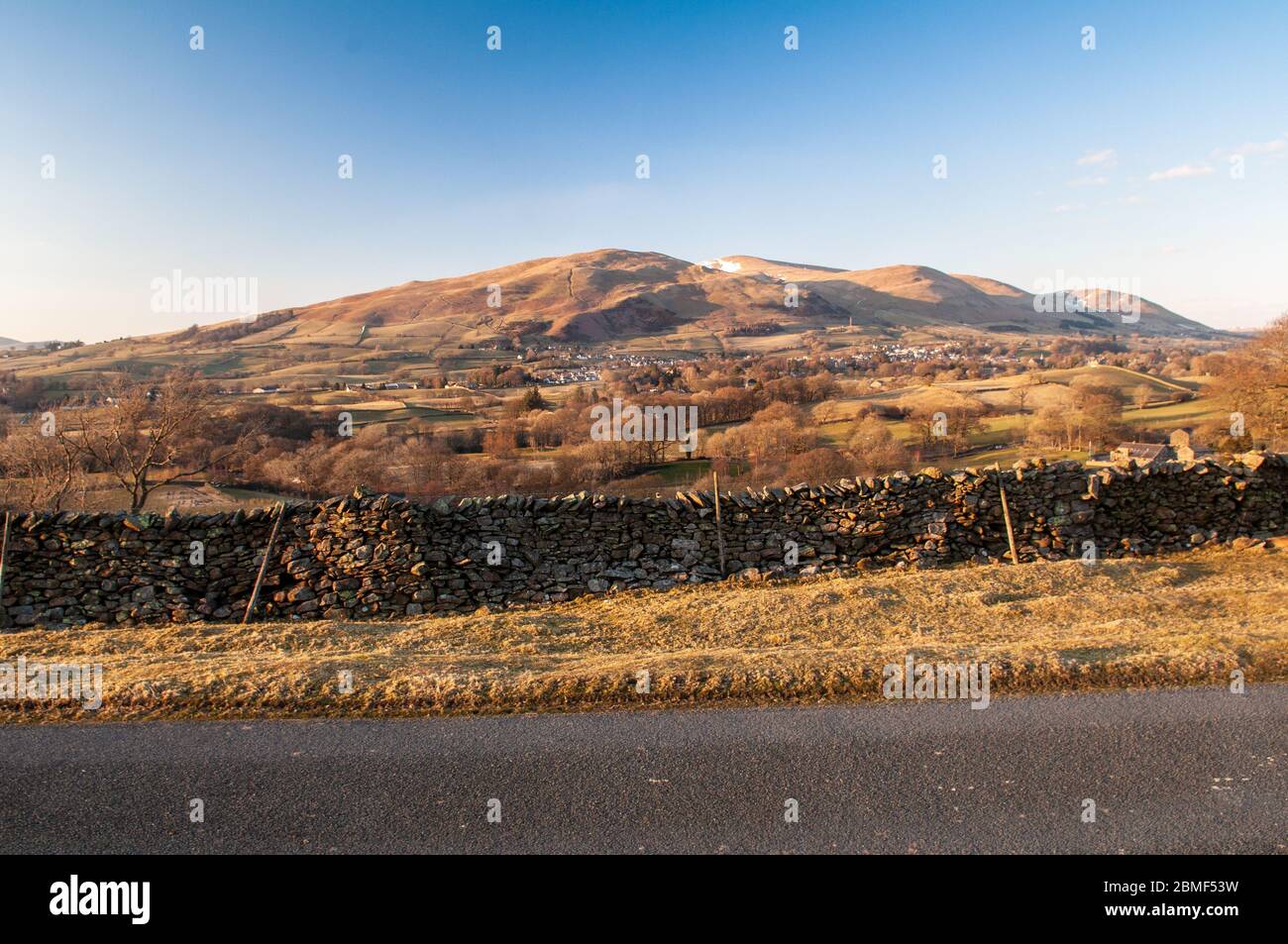 The snow-capped Howgill Fells hills rise bind the town of Sedbergh in the Yorkshire Dales National Park. Stock Photo