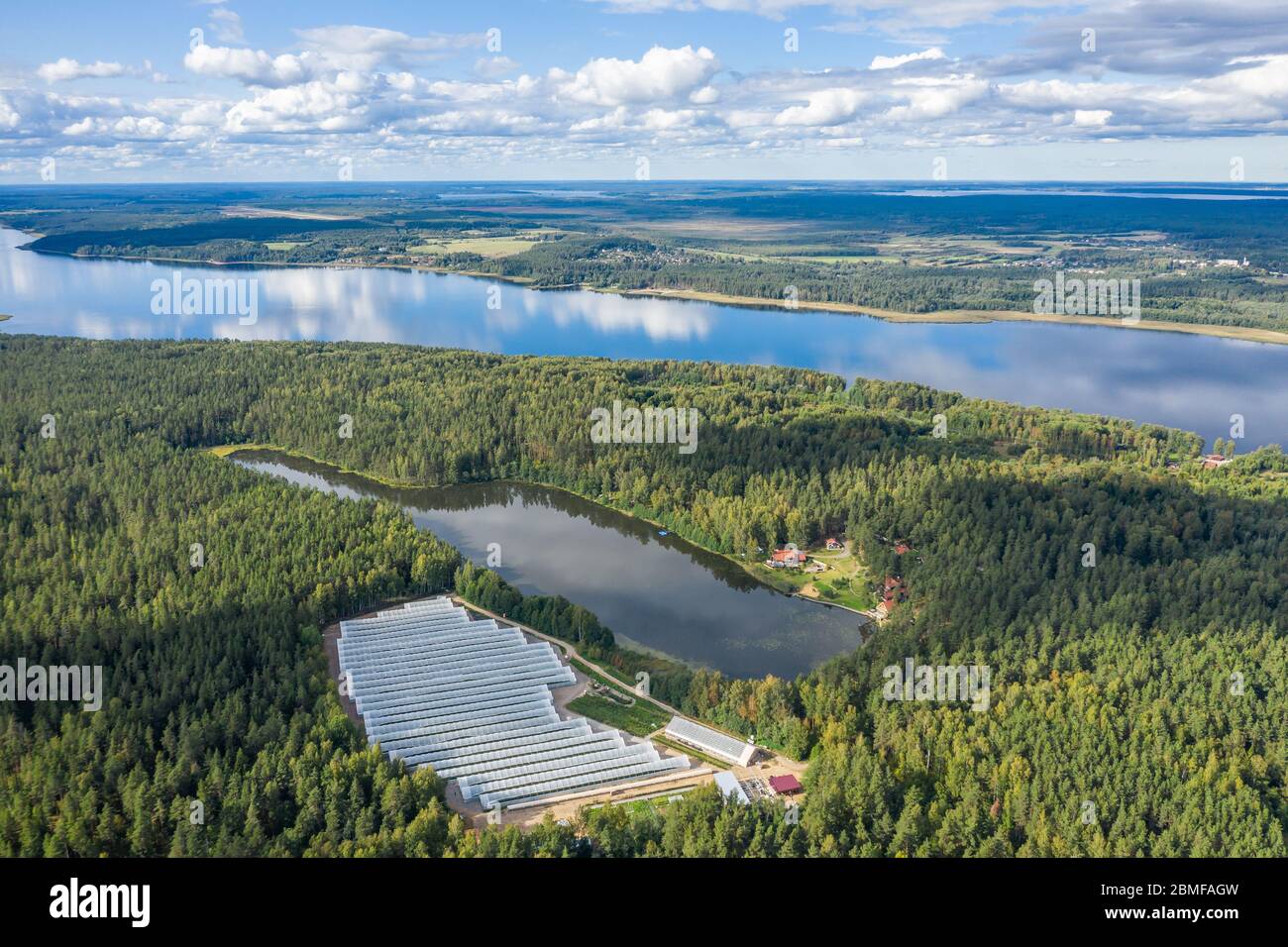Aerial view of greenhouses by the lake in the forest Stock Photo