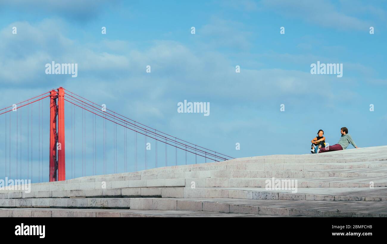 Juxtaposition of man and woman with Lisbon landmark Stock Photo
