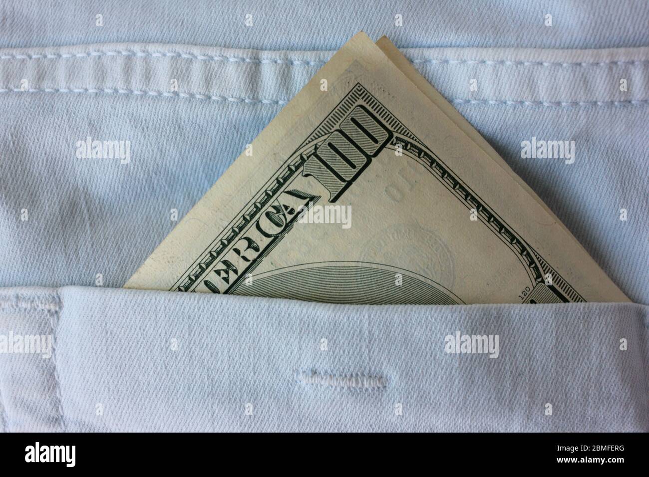 American money in the back pocket of blue jeans. Close-up of 100 dollars banknote. Stock Photo