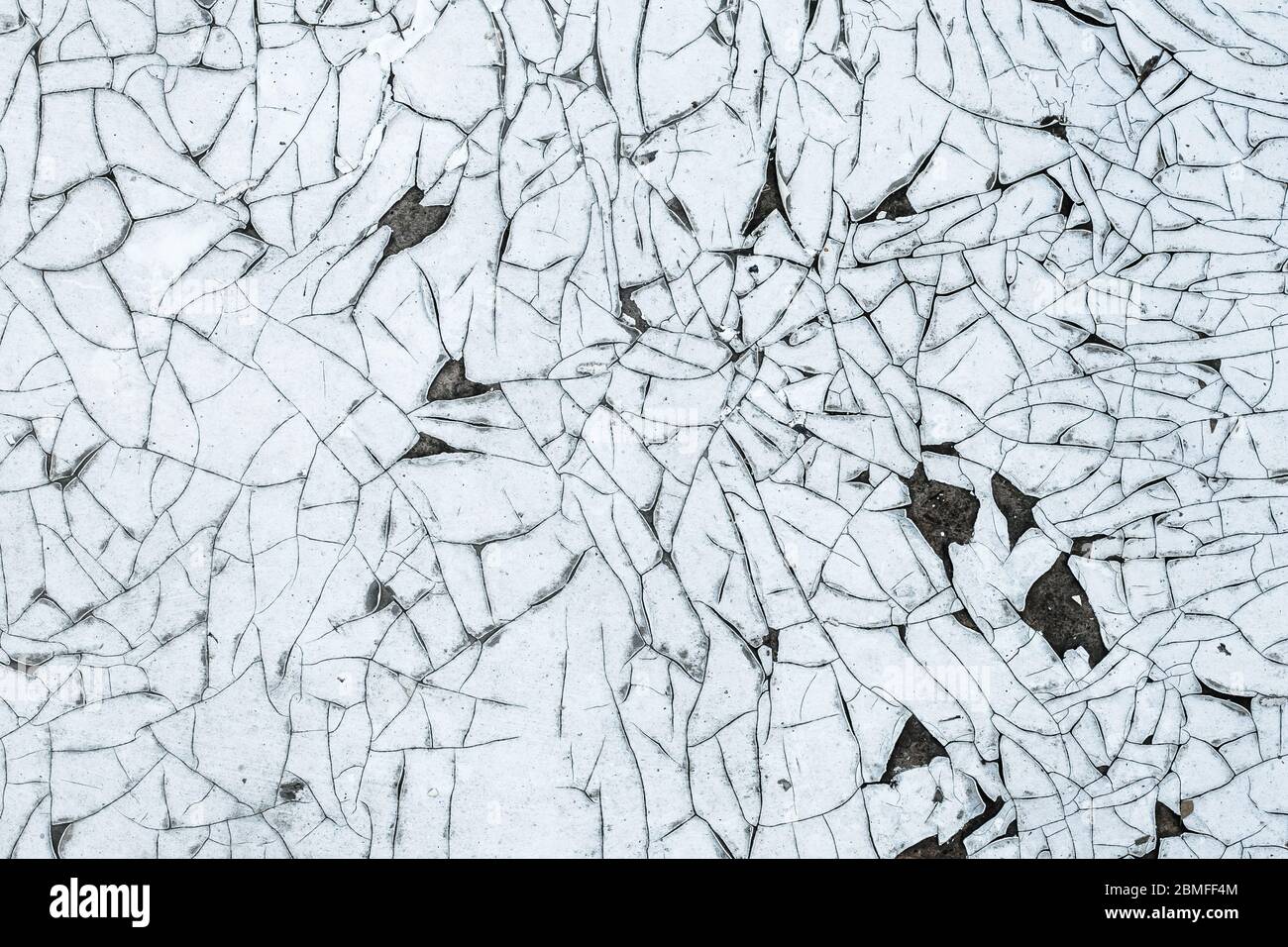 Cracked paint on the wall, flaky texture, white grunge background