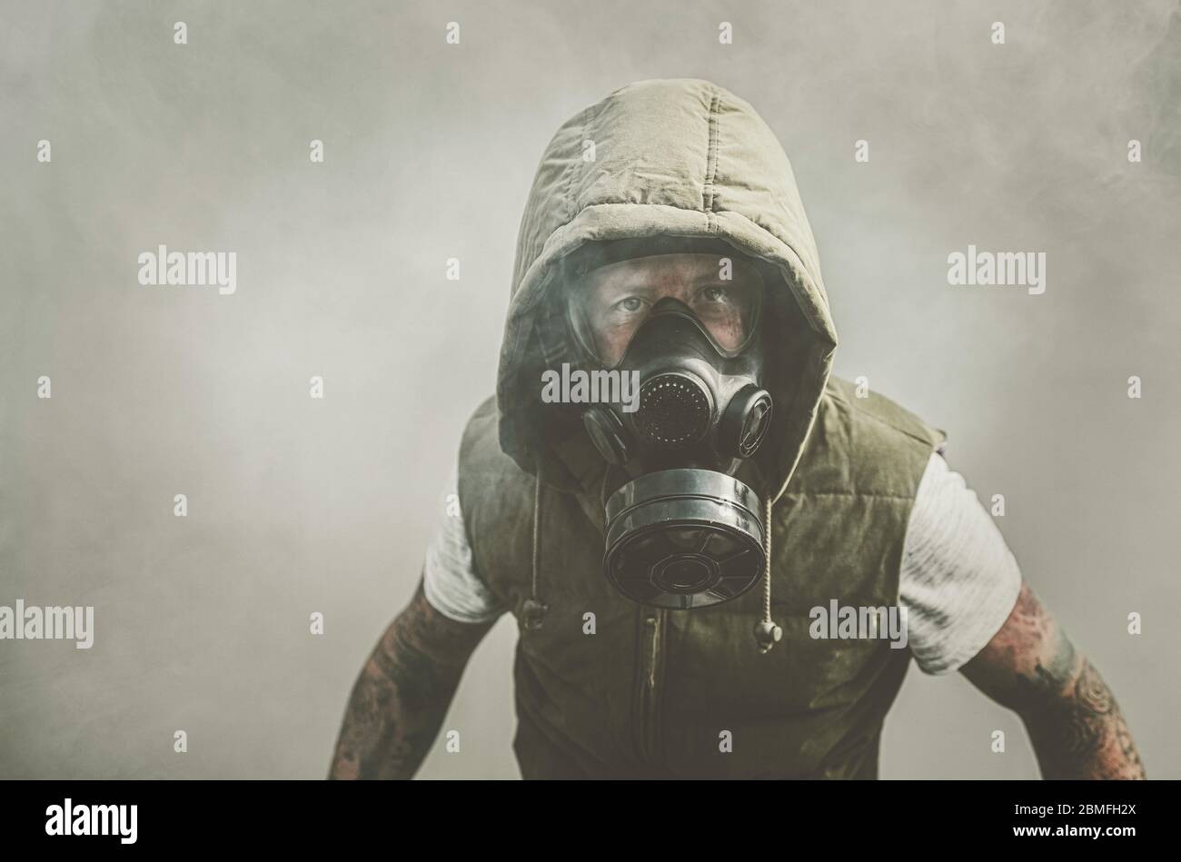 Man in gas mask surround by smoke Stock Photo