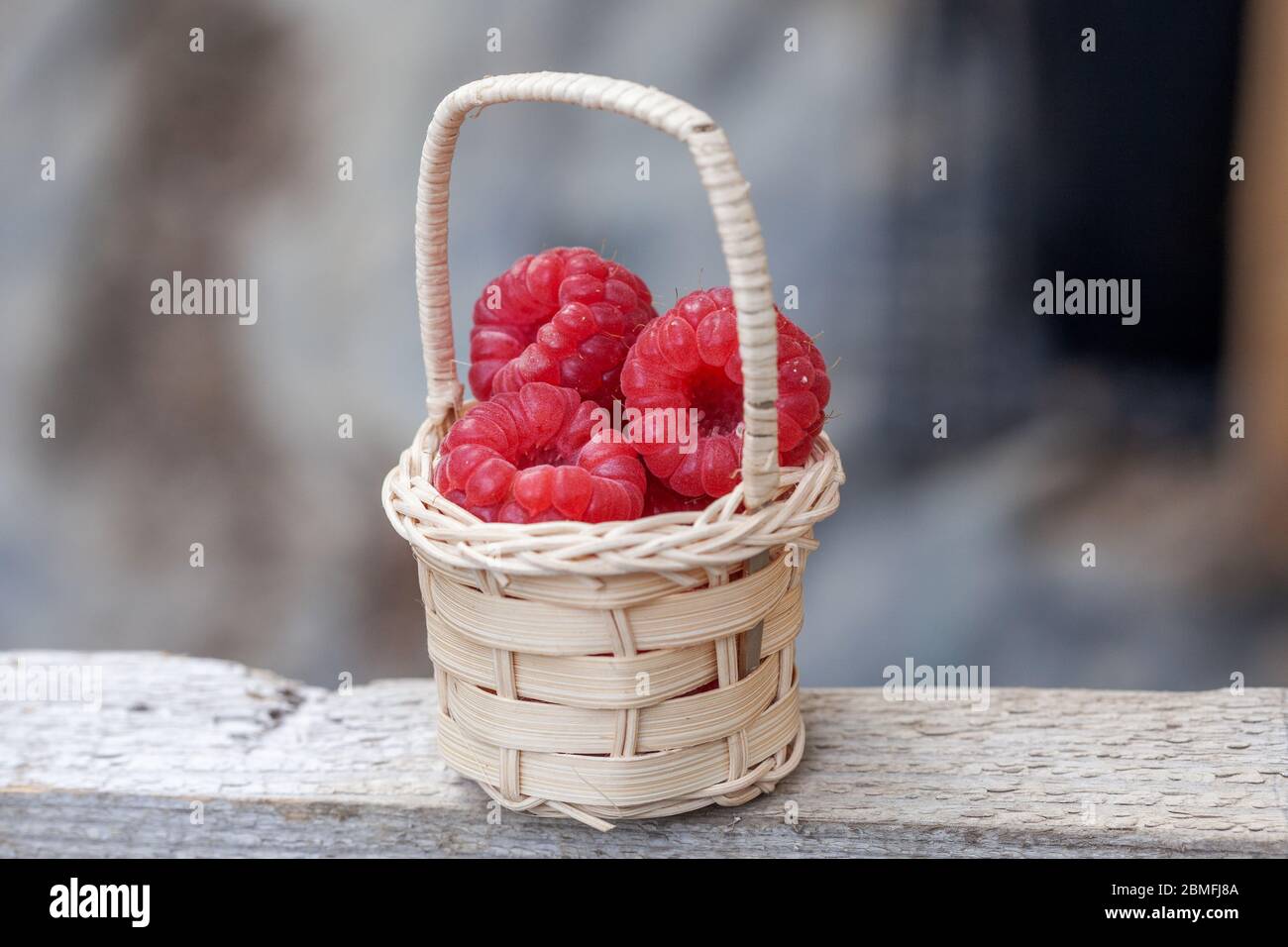 Wicker basket with red raspberries Stock Photo