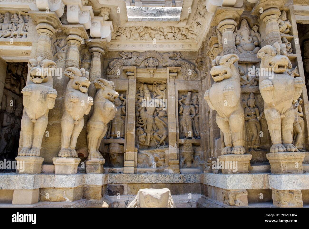 Stone-carved deities framed by sculpted pillars in the shape of lions, Kailasanathar Temple, Kanchipuram, Tamil Nadu, India. Stock Photo