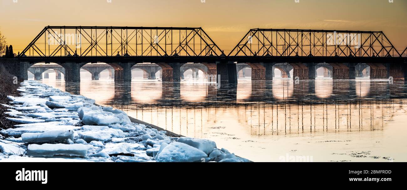 Ice chunks line the walkway toward a railroad bridge over the Susquehanna River in Harrisburg, Pennsylvania Stock Photo