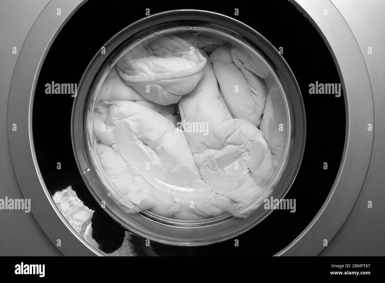 Washing machine door with rotating garments inside Stock Photo