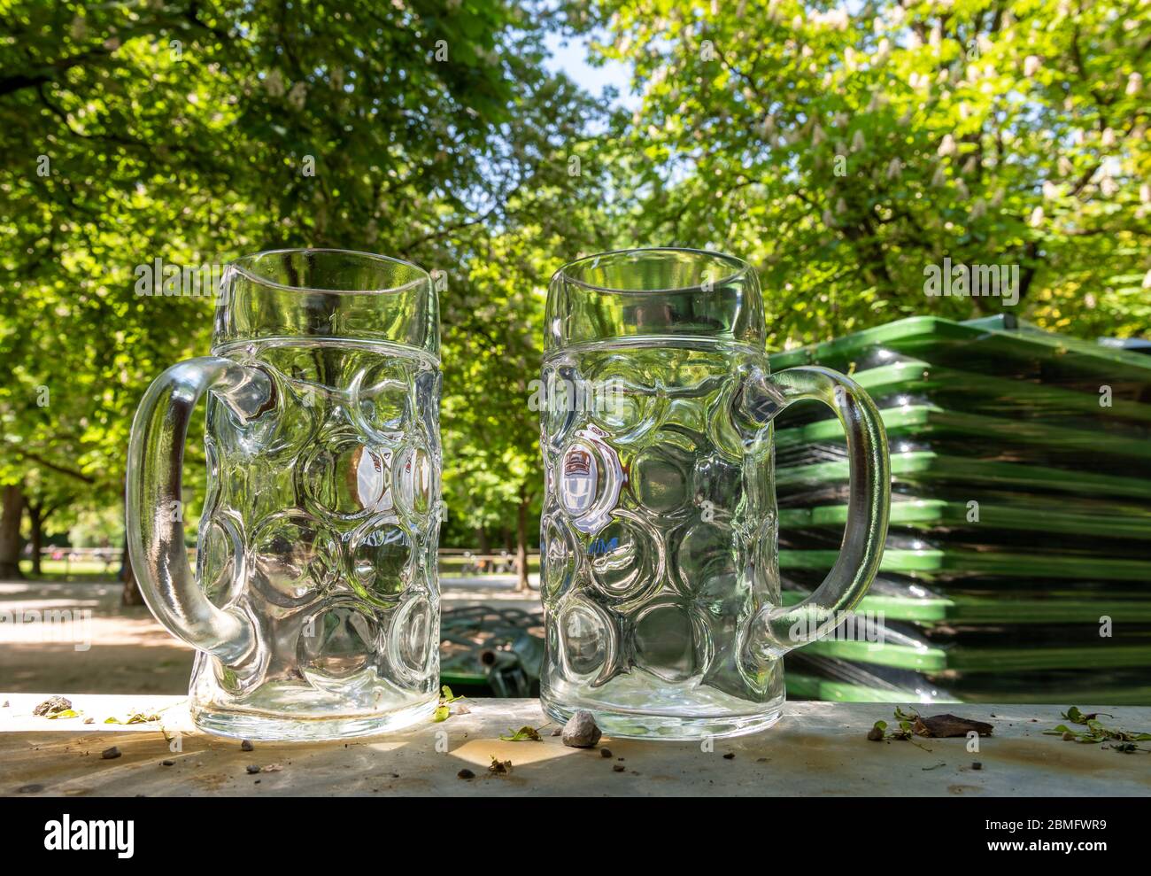 Munich, Germany. 09th May, 2020. Two empty beer mugs and assembled beer benches stand in the beer garden at the Chinese Tower, which is usually well attended at this time of day and in this weather. Credit: Peter Kneffel/dpa/Alamy Live News Stock Photo