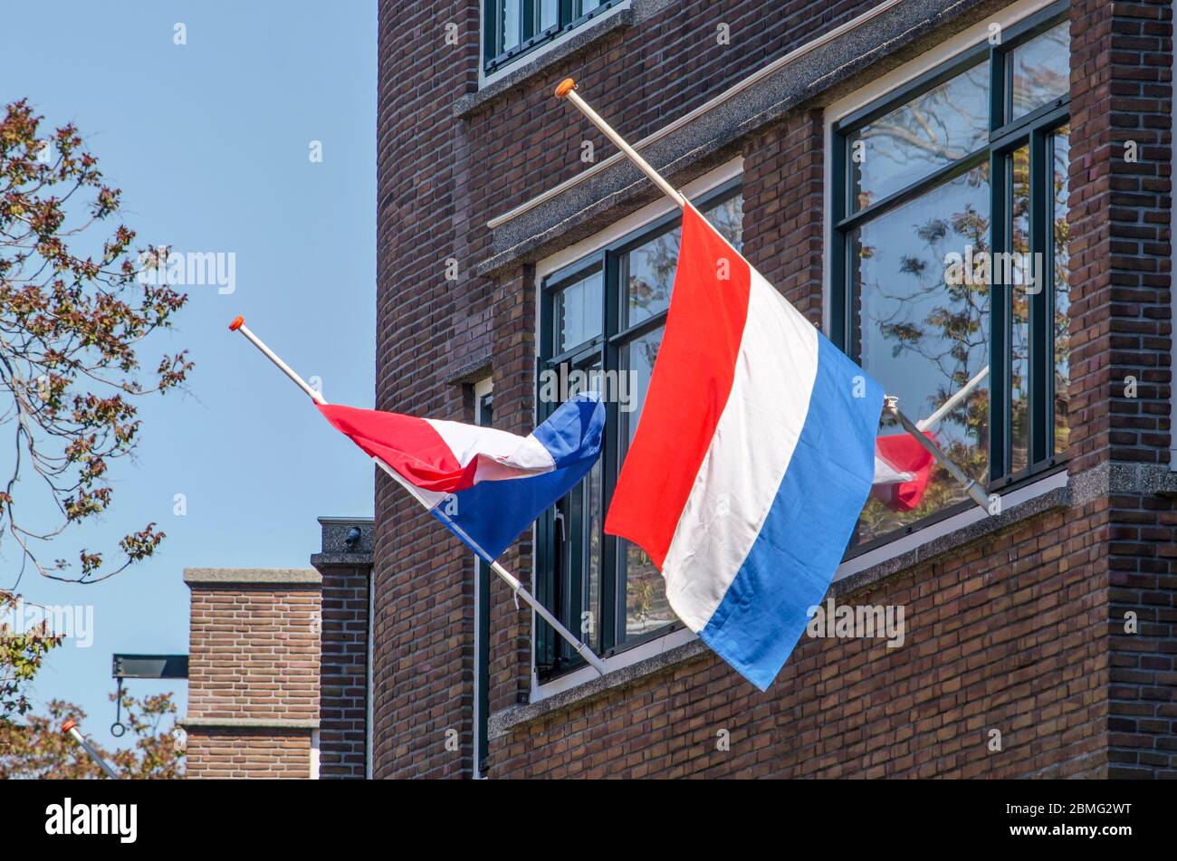 Rotterdam, The Netherlands, May 4, 2020 two flags halfmast in a