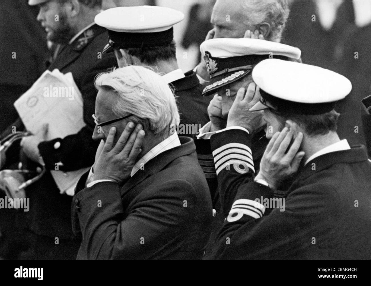 AJAXNETPHOTO. 31ST AUG 1975.LONDON, ENGLAND. - DEAF EARS - FT CLIPPER RACE -  MR EDWARD HEATH, PICTURED WITH EARS BOXED, WITH THE COMMANDER OF THE FRIGATE HMS LONDONDERRY AND OTHER OFFICERS AS THE SHIP'S  SALUTING CANNON WAS FIRED TO START FOUR YACHTS ON A RECORD BREAKING ATTEMPT TO REACH SYDNEY, AUSTRALIA, IN UNDER 69 DAYS.  PHOTO:JONATHAN EASTLAND/AJAX REF:750209 4 75 Stock Photo