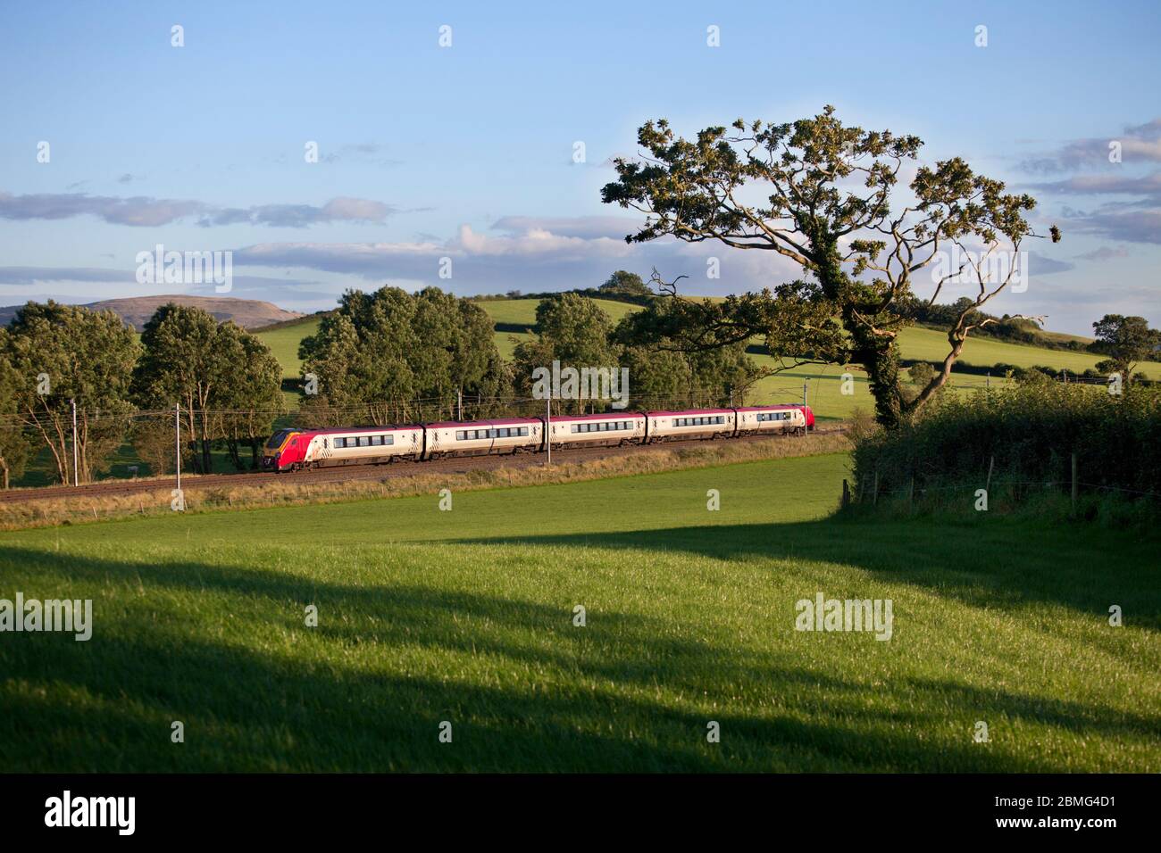 Virgin Trains Bombardier class 221 diesel voyager train in the countryside on the electrified west coast mainline in Cumbria. Stock Photo