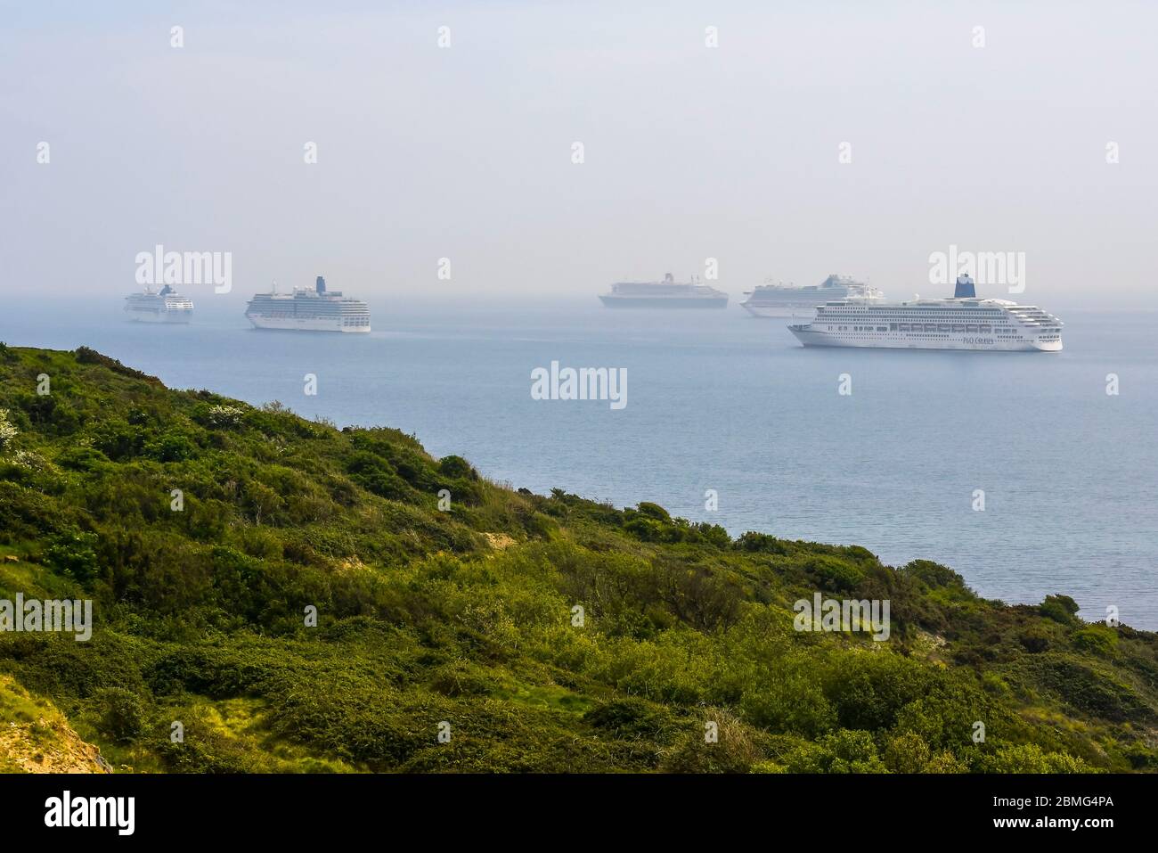 Weymouth, Dorset, UK. 9th May 2020. UK Weather: Five cruise ships anchored in the bay off the coast of the seaside resort of Weymouth in Dorset on a hot sunny day due to the cruising industry shutting down during the coronavirus lockdown. There are four P&O ships which are The Oceana, Aurora, Arcadia and Ventura and one Cunard ship the liner Queen Mary 2. Picture Credit: Graham Hunt/Alamy Live News Stock Photo