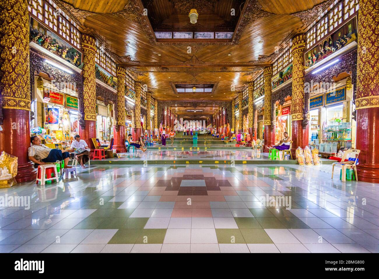 YANGON, MYANMAR - OCTOBER 16, 2015: Stalls and vendors line the corridor from the southern entrance to Shwedagon Pagoa. Stock Photo