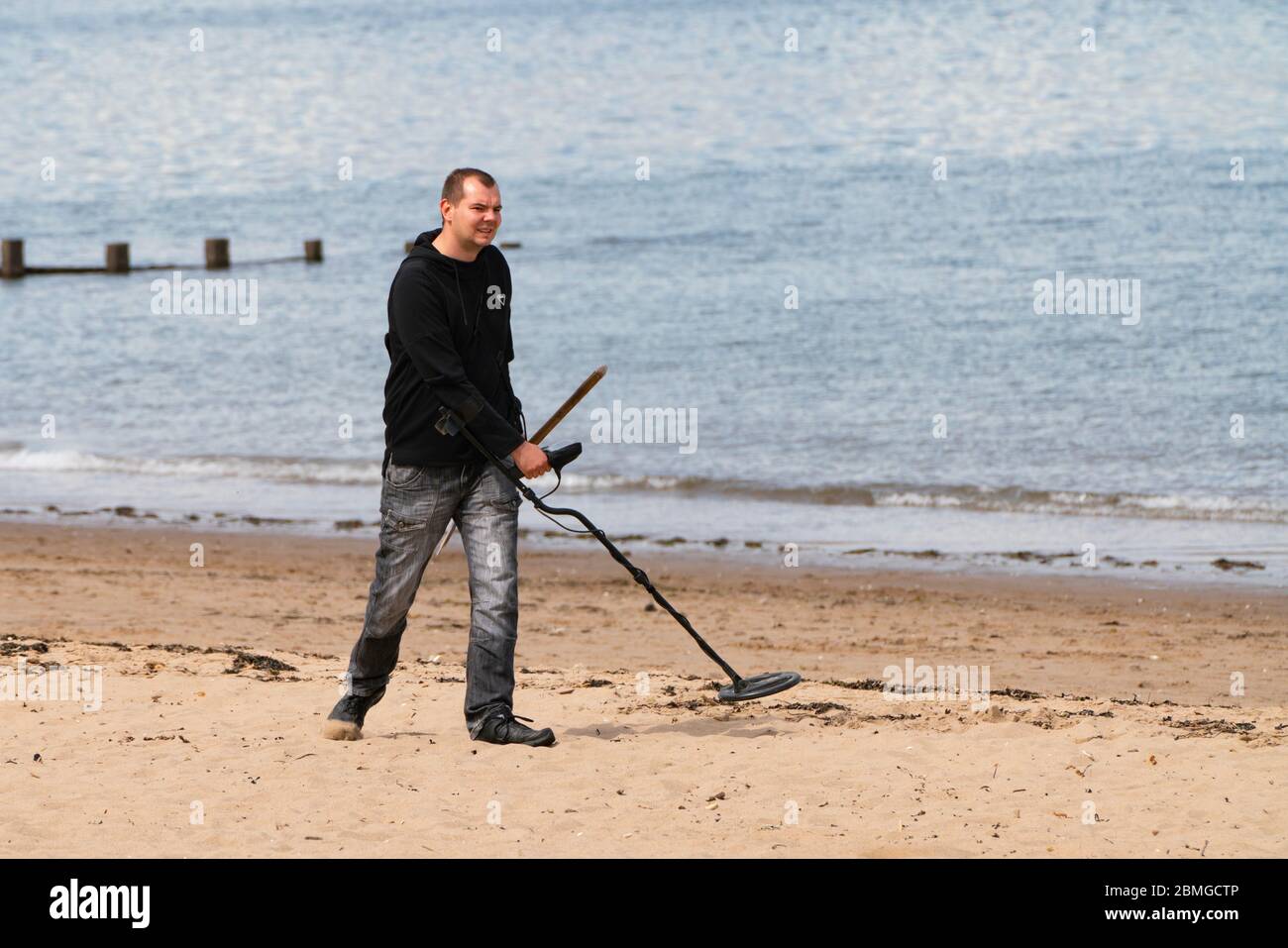 Portobello, Scotland, UK. 9 May 2020. Images from holiday weekend Saturday afternoon during Covid-19 lockdown on promenade at Portobello. Promenade and beach were relatively quiet with a low key police presence. Pictured;  Man with metal detector on the beach. Iain Masterton/Alamy Live News Stock Photo