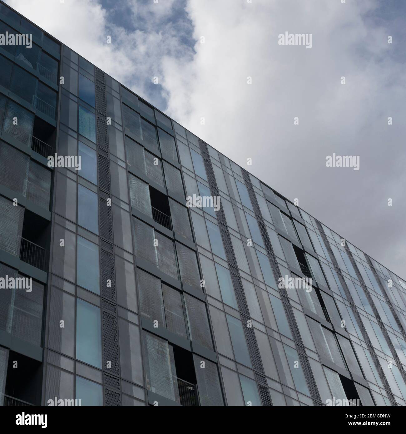 The sky reflected in the glass windowed facade of Hartley House, Bermondsey, London, England Stock Photo