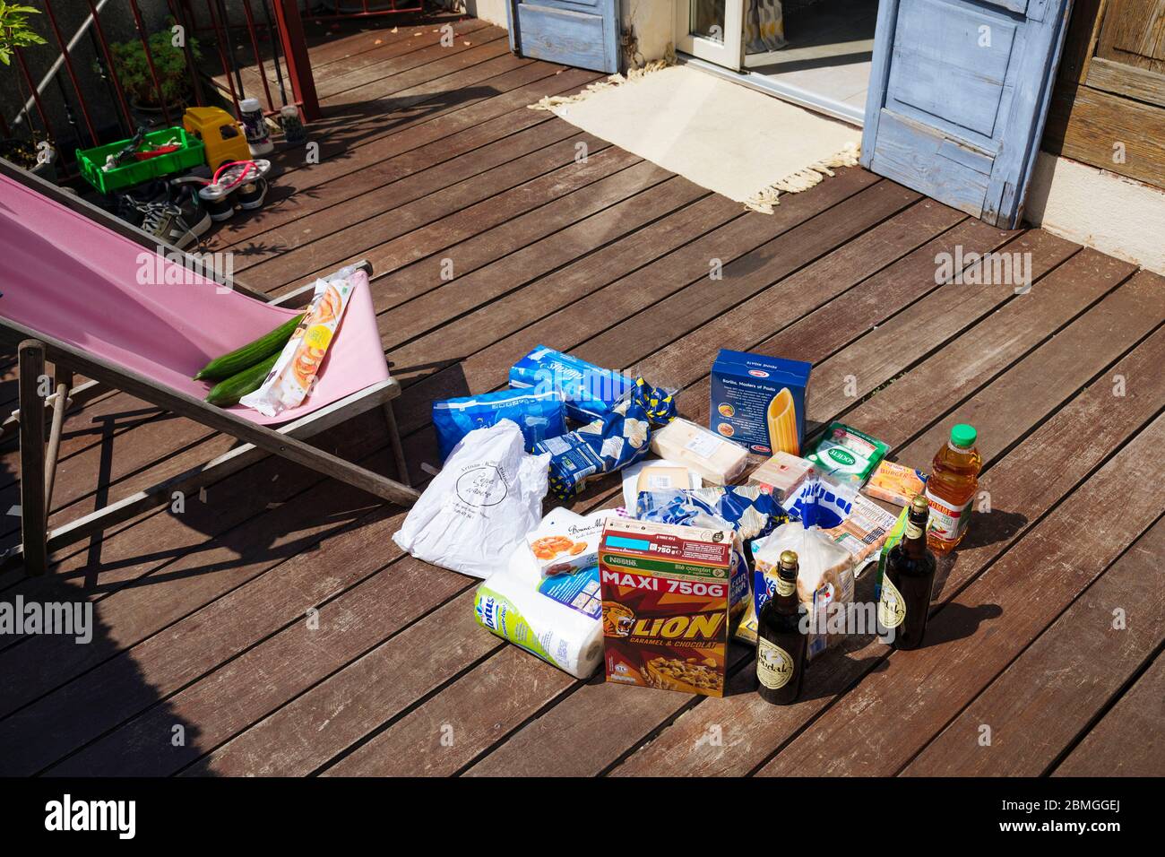 Illustration, grocery shopping, products and their packaging are left outside in the sun, on a terrace. According to some studies, the sun and heat co Stock Photo