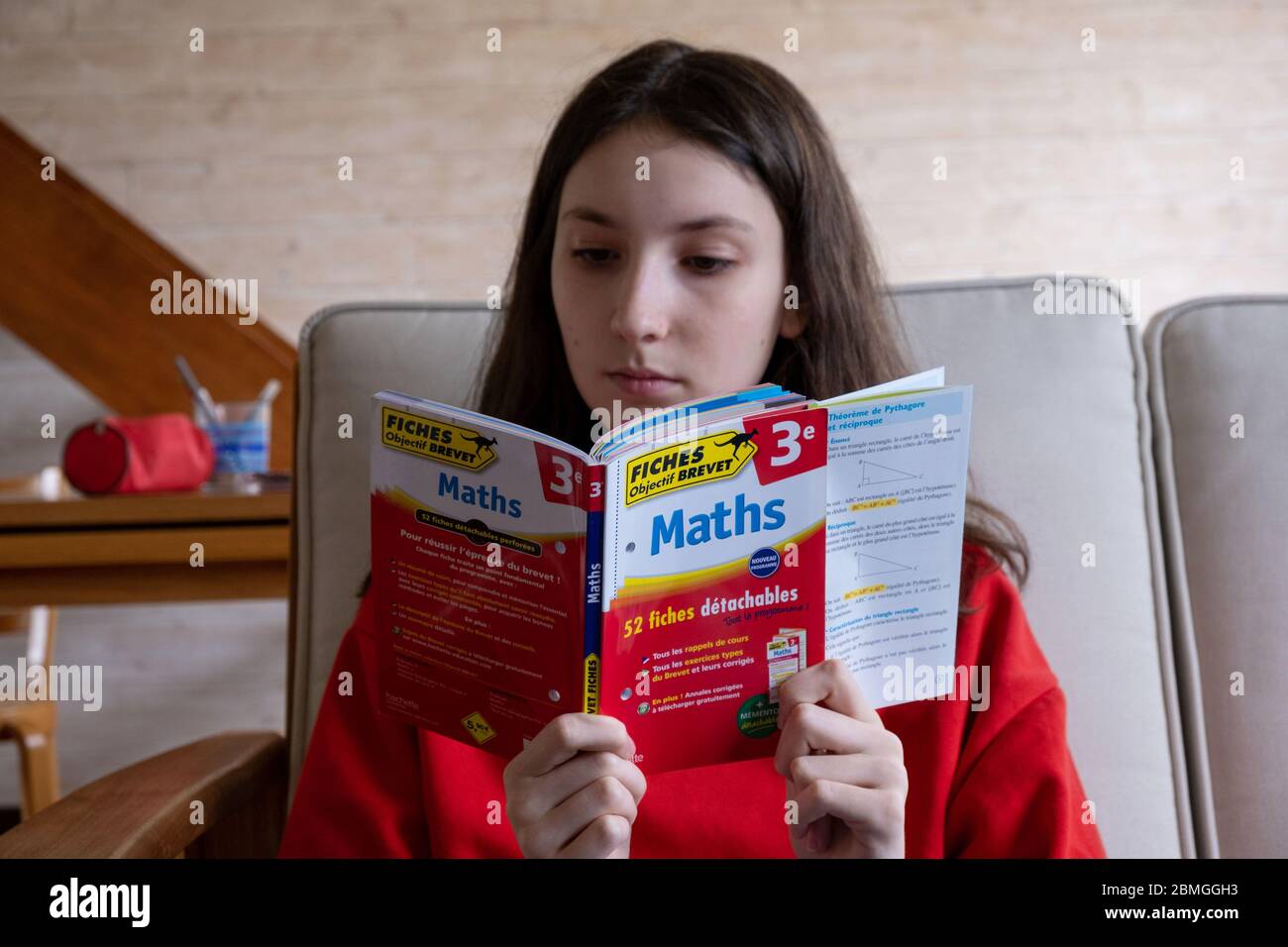 Junior school certificate (French Brevet des colleges): junior high school student busy revising the work she has done over the year. Here, revising f Stock Photo