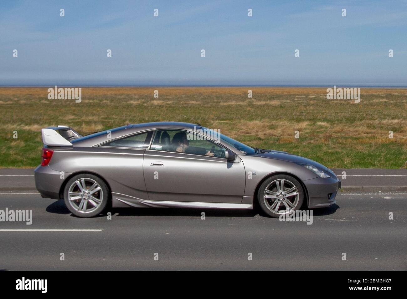 2006 silver Toyota Celica Vvtl-I GT; UK Vehicular traffic, road transport, modern vehicles, saloon cars, vehicle driving, roads & motors, motoring south-bound on the coast road in Southport, UK Stock Photo