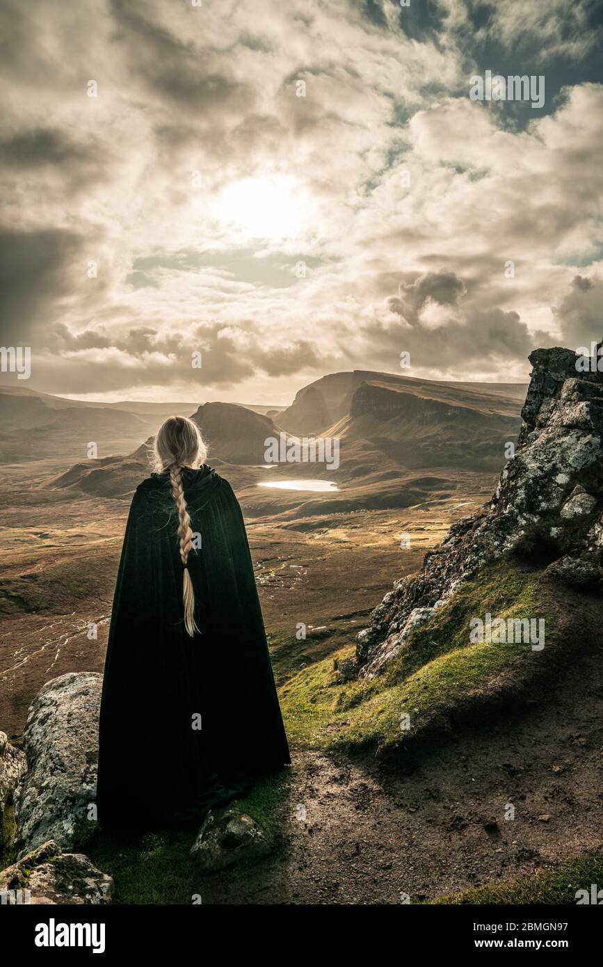 A cloaked figure wandering through a landscape beyond compare Stock Photo -  Alamy