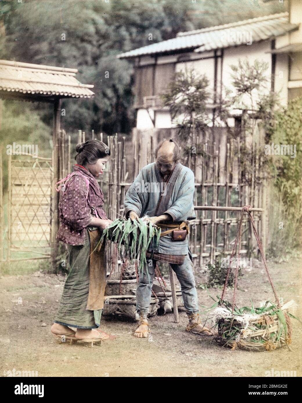 [ 1890s Japan - Japanese Vegetable Vendor ] —   A street vendor with baskets of vegetables meets a customer on the street.  Japanese streets used to be full of vendors peddling everything from food to baskets to medicine.  19th century vintage albumen photograph. Stock Photo