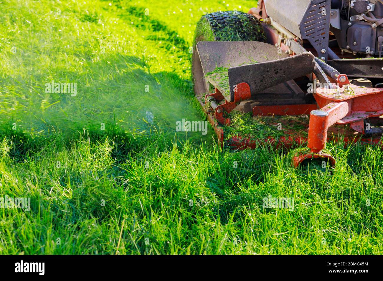 Gardener cutting grass using lawnmower hi res stock photography and