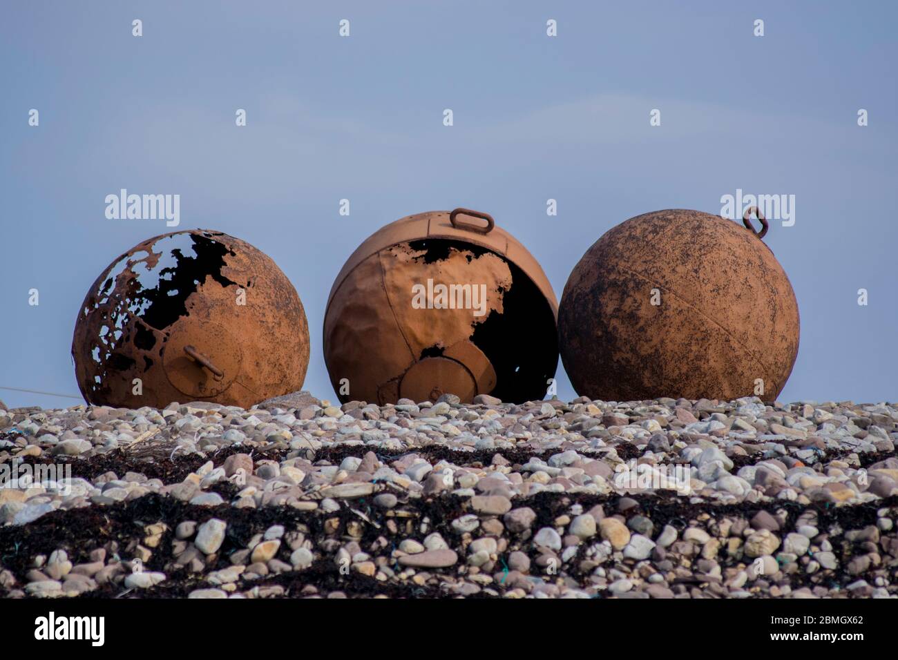 Three large rusty buoys on the shore Stock Photo