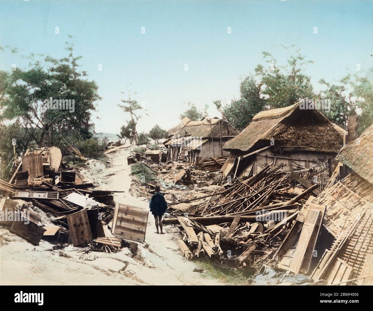 [ 1890s Japan - Nobi Earthquake Destruction ] —   Devastation in Ichinomiya (一の宮村) in Aichi Prefecture caused by the Nobi Earthquake (濃尾地震, Nobi Jishin) of October 28, 1891 (Meiji 24).  Debris is piled up along a cracked road. The Nobi Earthquake measured between 8.0 and 8.4 on the scale of Richter and caused 7,273 deaths, 17,175 casualties and the destruction of 142,177 homes.  It is the largest recorded quake in inland Japan. It jumpstarted the study of seismology in Japan and proved that earthquakes are caused by fault lines.  19th century vintage albumen photograph. Stock Photo