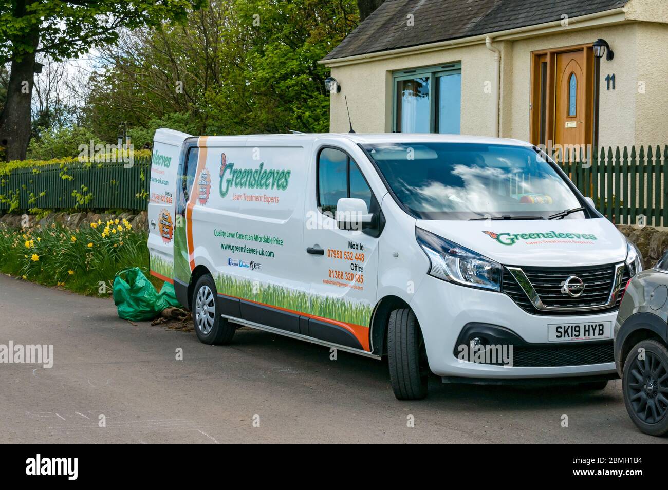 Greensleeves gardening service and lawn treatment workman's van parked outside house, East Lothian, Scotland, UK Stock Photo