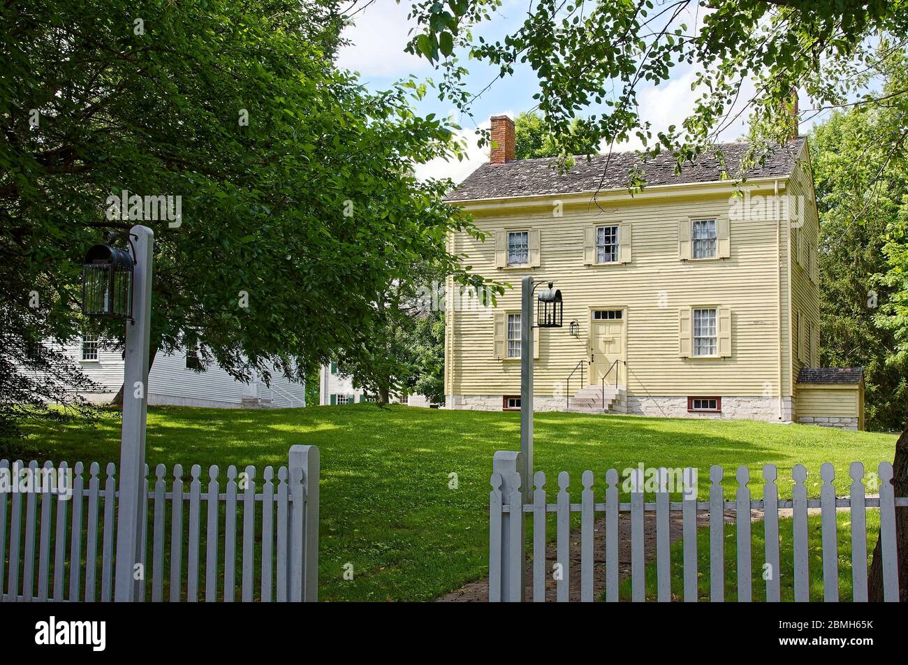 Ministry's Workshop, 1821, clapboard building, plain, old, picket fence, hanging lanterns, trees, sun, shade, Shaker Village of Pleasant Hill; defunct Stock Photo
