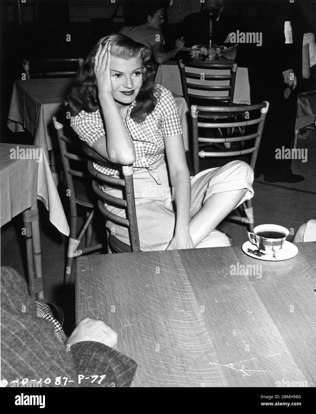 RITA HAYWORTH SITTING on a sofa during a press conference on the o