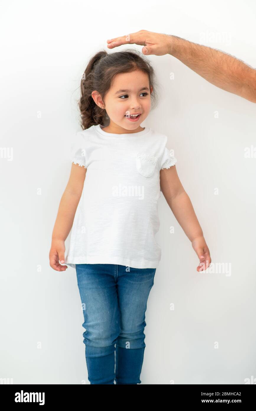 https://c8.alamy.com/comp/2BMHCA2/father-measuring-height-of-a-cute-child-dad-measures-the-growth-of-her-child-daughter-at-a-blank-white-wall-2BMHCA2.jpg