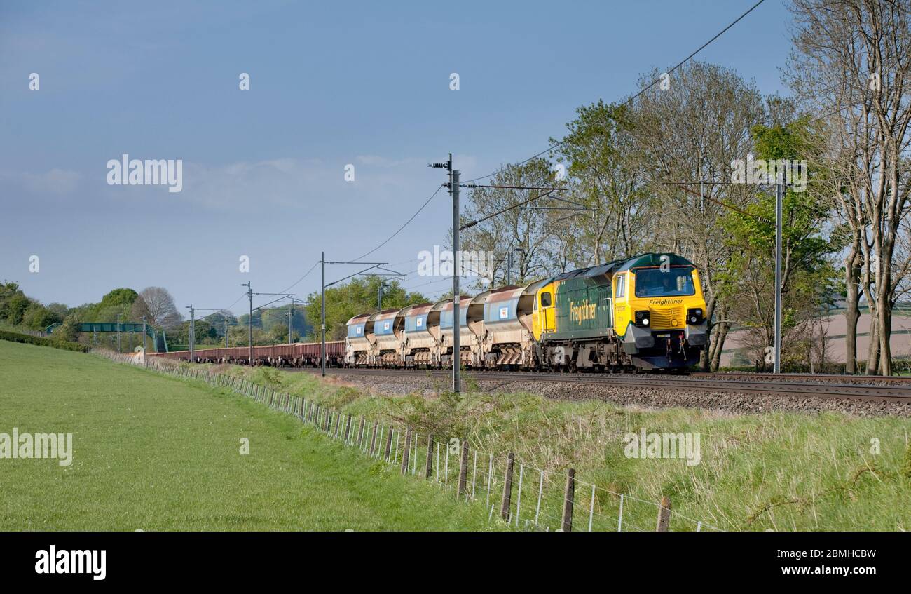 Freightliner GE class 70 diesel locomotive 70016 on the electrified west coast mainline with a freight train carrying materials for Network Rail Stock Photo