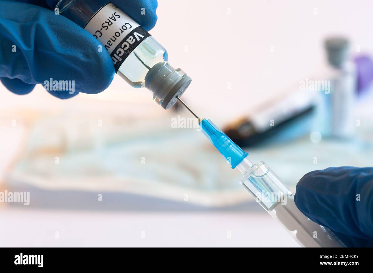 Coronavirus COVID-19 vaccine vial and injection syringe in medic hands ...