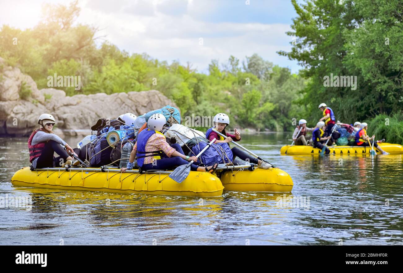 A group of people rafting on a stormy river in the yellow rafts fully ...