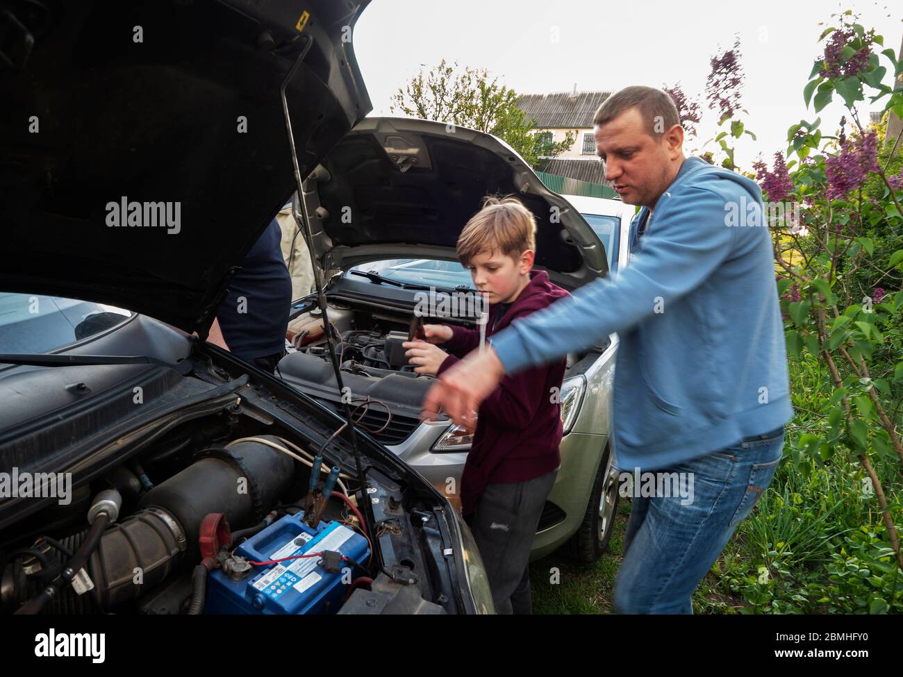 The father explains to his son how to properly connect the battery of