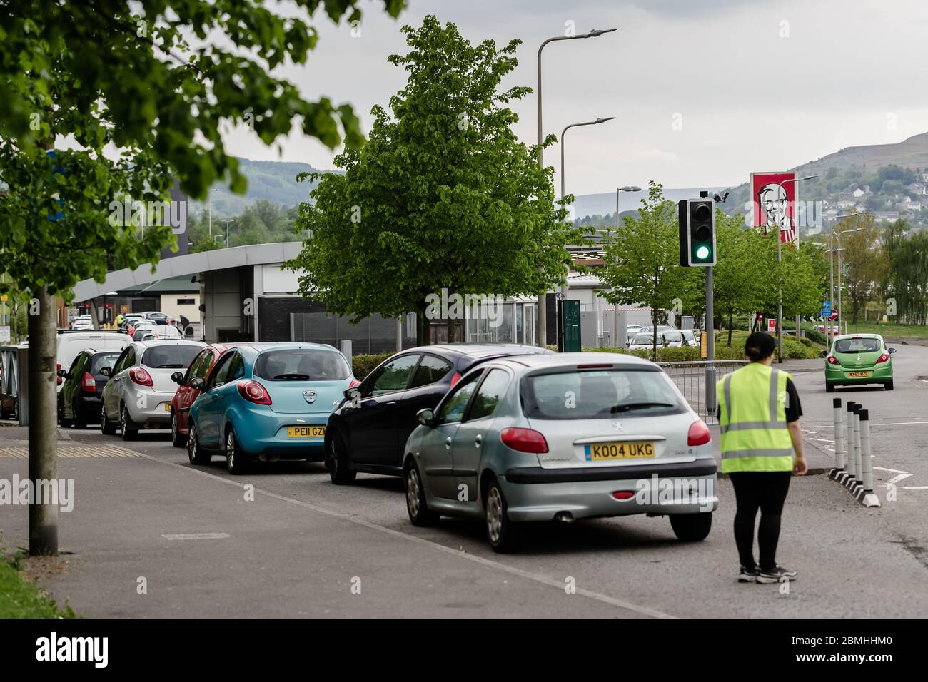 MERTHYR TYDFIL, WALES - 09 MAY 2020: KFC worker stops cars entering the driver through to KFC as its full. Stock Photo