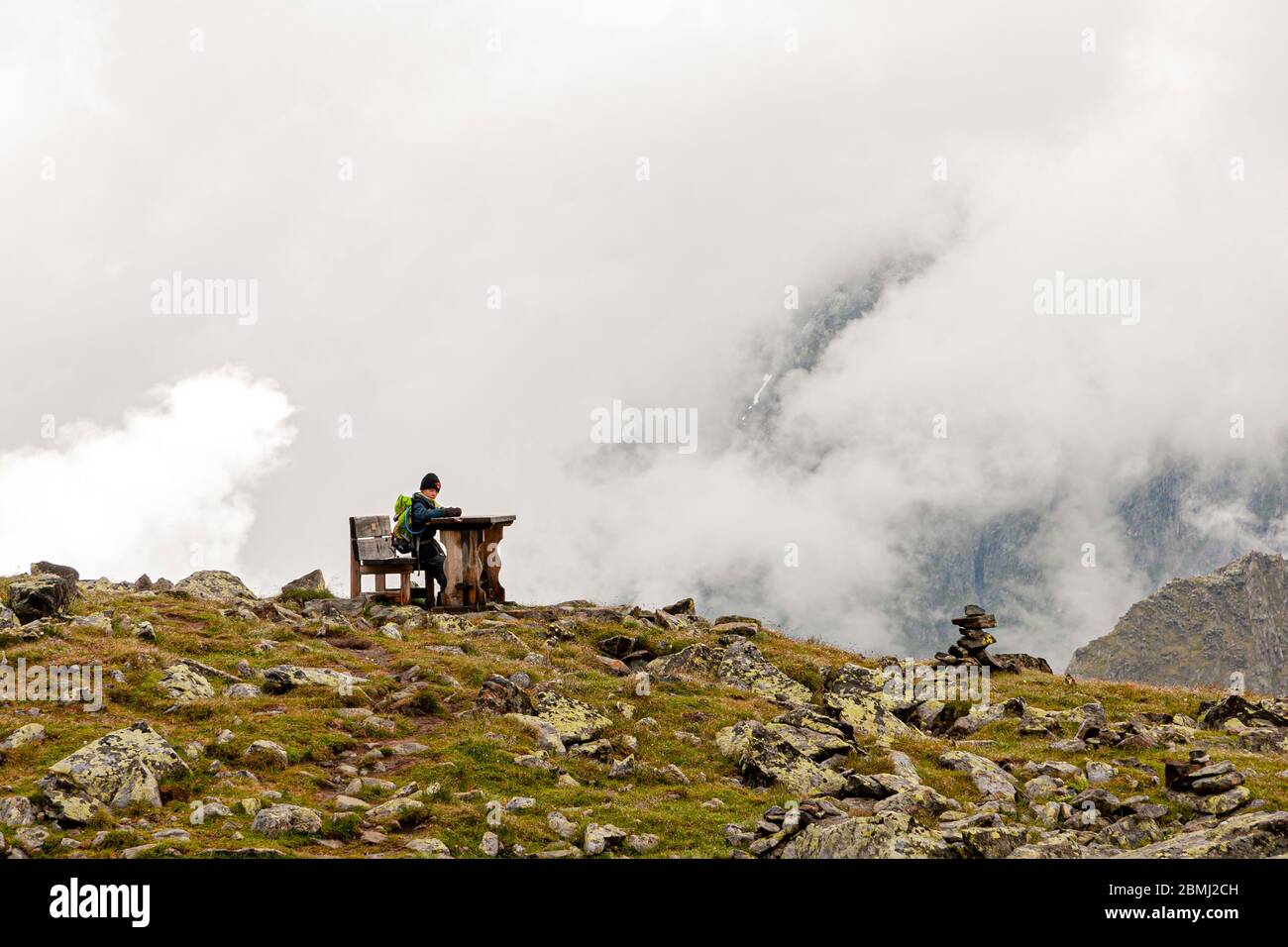 Young Boy picnicking alone in the foggy Mountains of Neustift im Stubaital, Austria Stock Photo